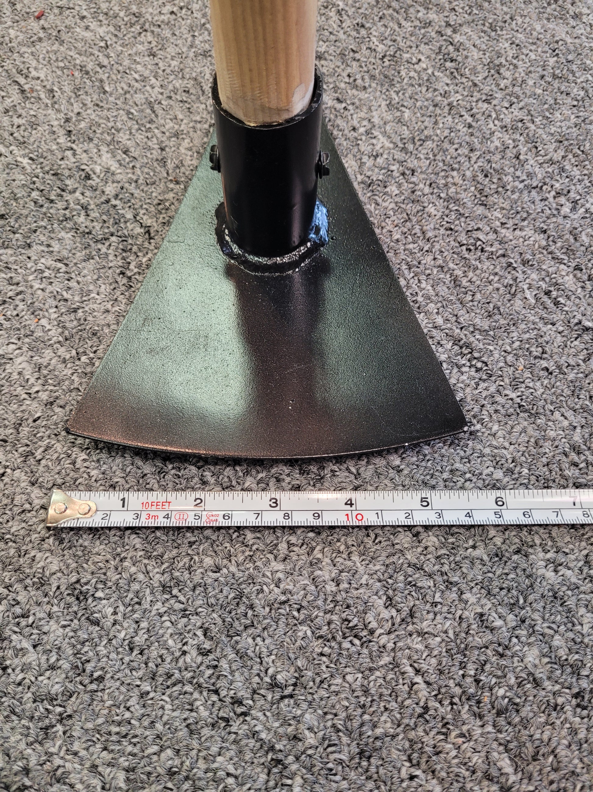 The blade of the head of the pick is against a tape measure. The blade measures 5.5 inches across
